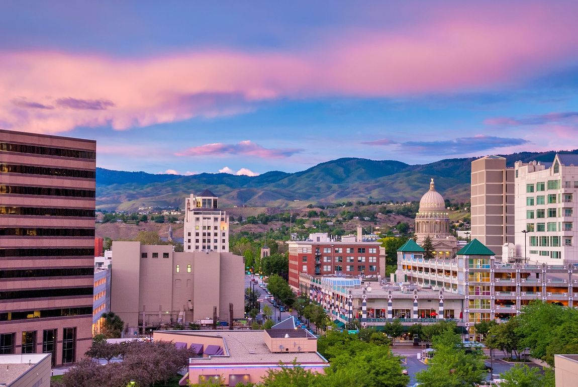 City skyline at sunset with a pink and blue sky — boise apartments for rent