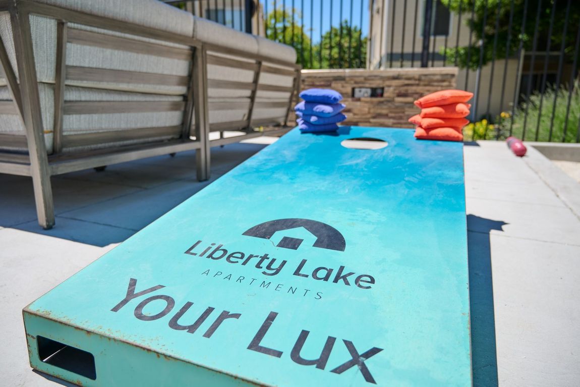 Cornhole game board with blue and orange bean bags — boise apartments for rent