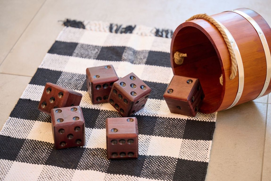 Six wooden dice scattered on a checkered mat — boise apartments for rent