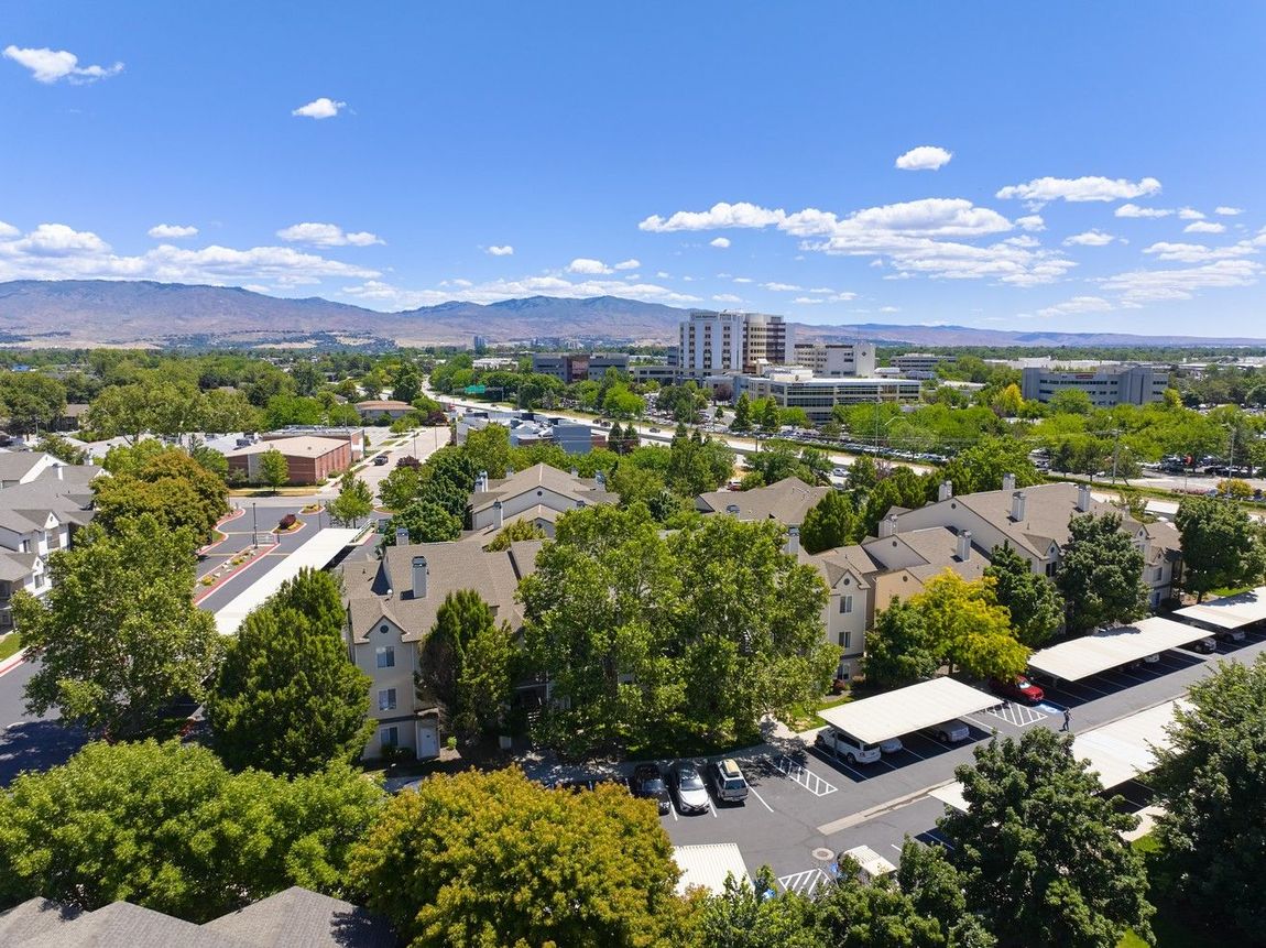 Aerial view of a city with buildings and green trees — boise apartments for rent