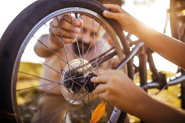 Working on a bicycle wheel outdoors — Apartments for Rent Boise