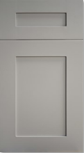 Gray cabinet door with a small top drawer and a larger lower panel.