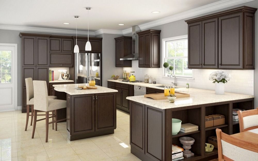 Modern kitchen with dark wood cabinets, white island, pendant lights, and bright windows