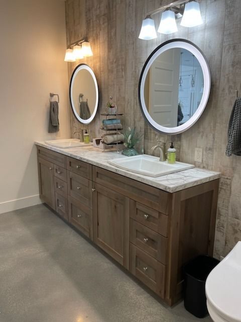 Modern bathroom with double wood vanity, round mirrors, and pendant lights