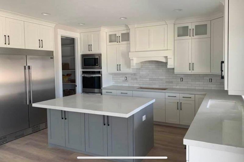 Bright modern kitchen with white cabinets, stainless steel appliances, and a gray island