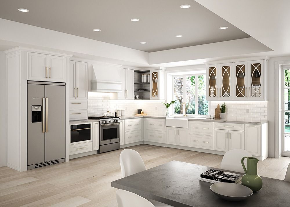 Bright white modern kitchen with stainless appliances, island, and dining table by a window