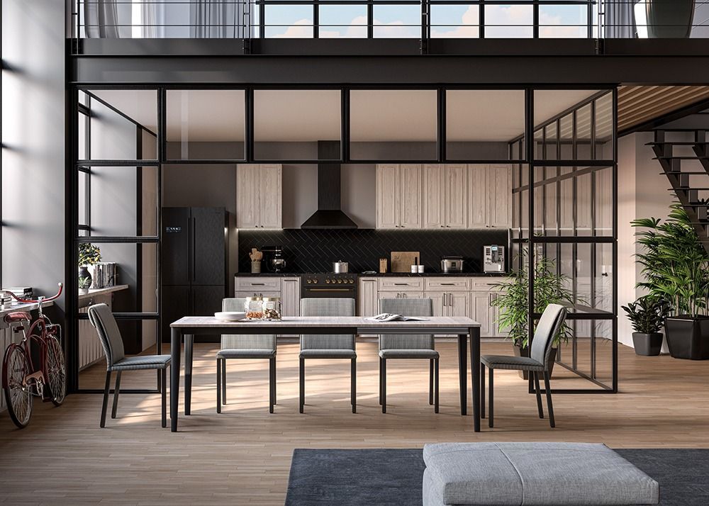 Modern open-plan kitchen and dining area with black metal frames, wood floors, and large windows