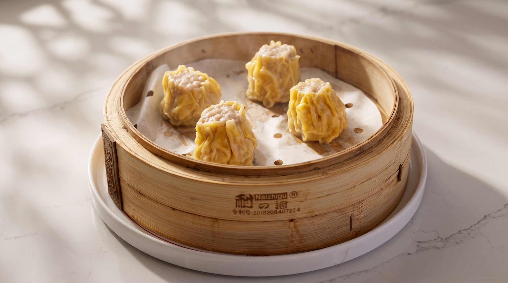 Four steamed dumplings in a bamboo steamer on a white plate, lit by soft sunlight.