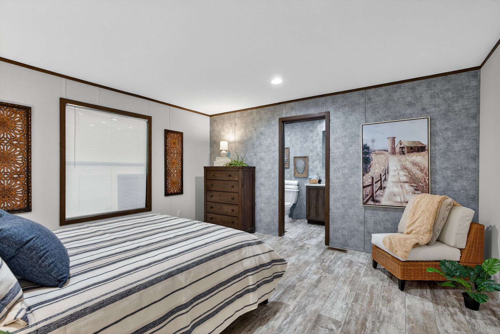 Modern bedroom with striped bedspread, dresser, window blinds, chair, and gray textured walls