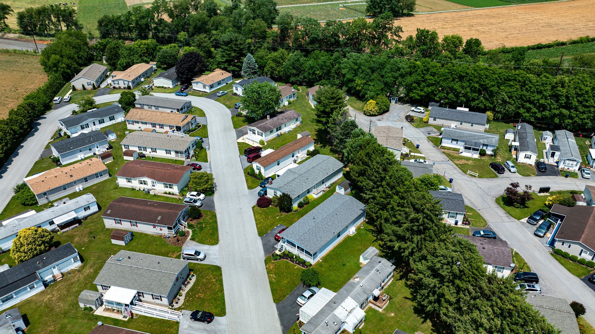Aerial view of a suburban neighborhood with rows of houses, streets, and trees
