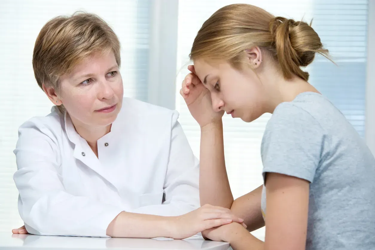Doctor consulting with a distressed patient in a bright clinic office