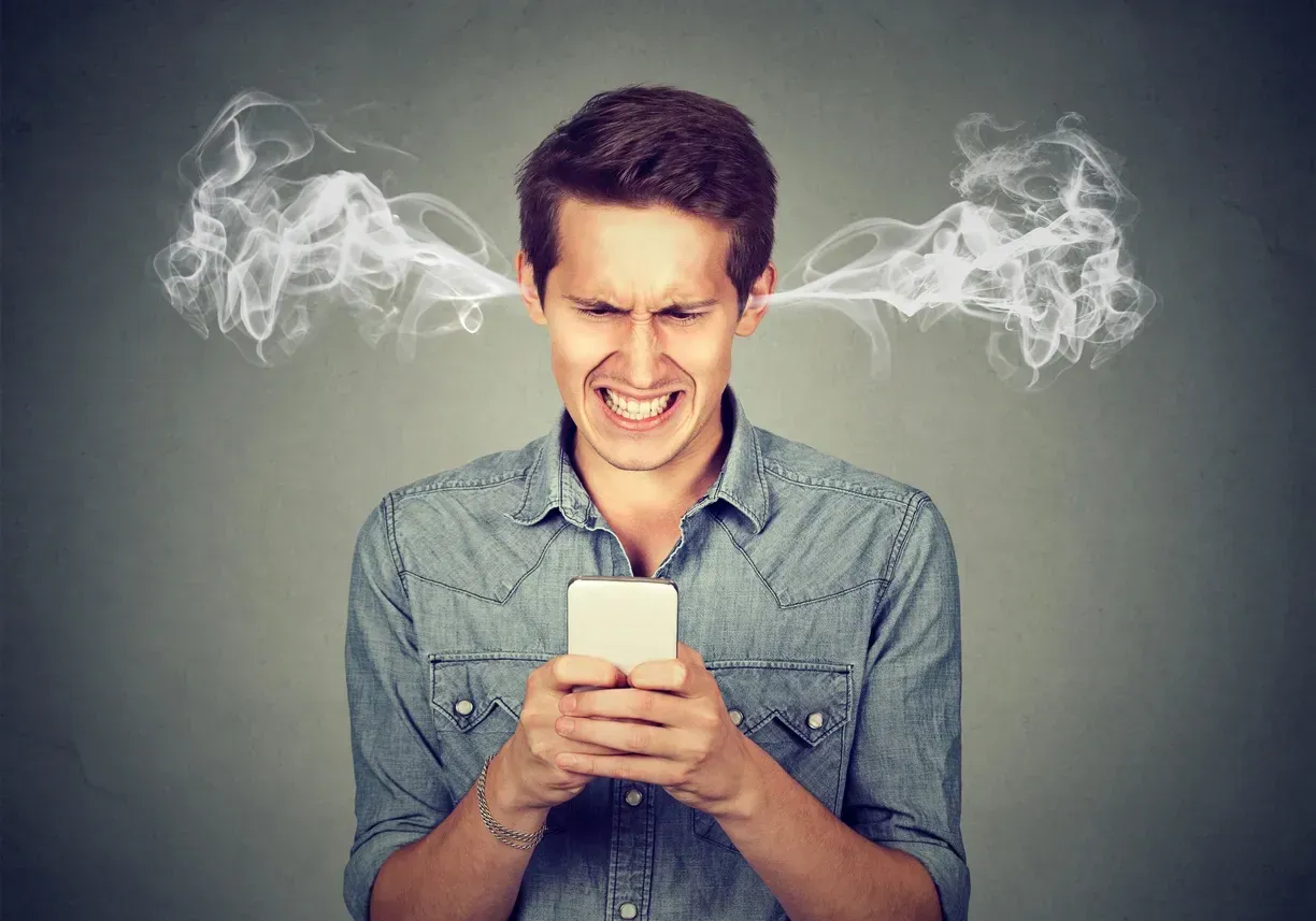 Frustrated person staring at a smartphone, with steam-like smoke coming from both sides of their head