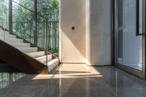 There is a staircase in the middle of the room with a glass railing.