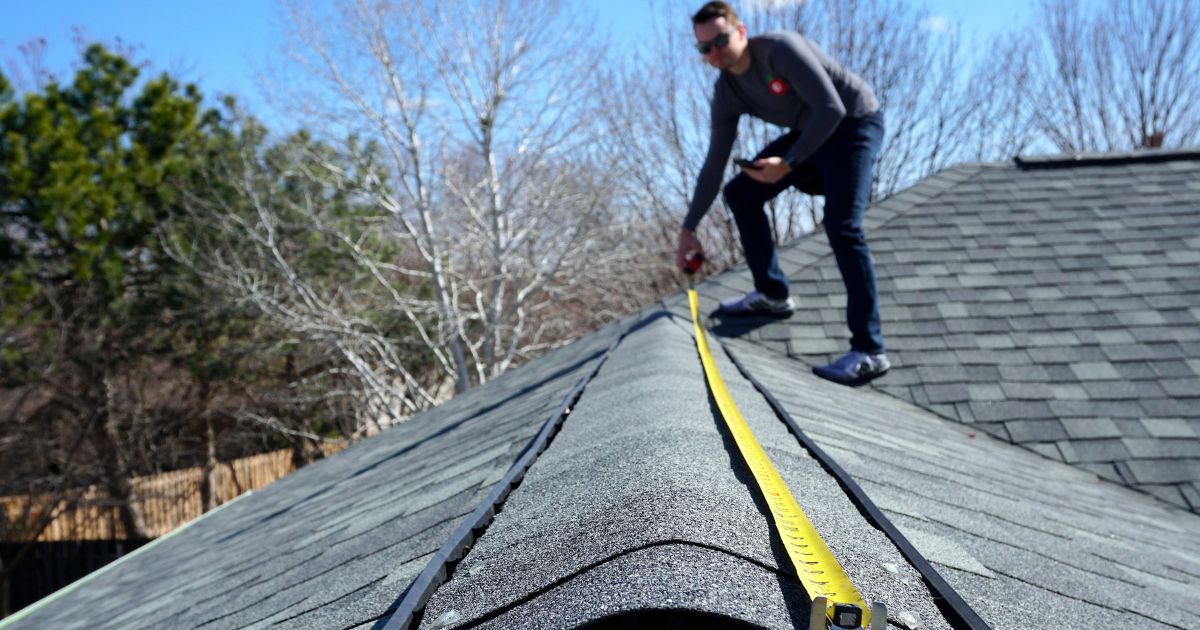 Public adjuster measuring a residential roof during a claim inspection in Dallas Fort Worth