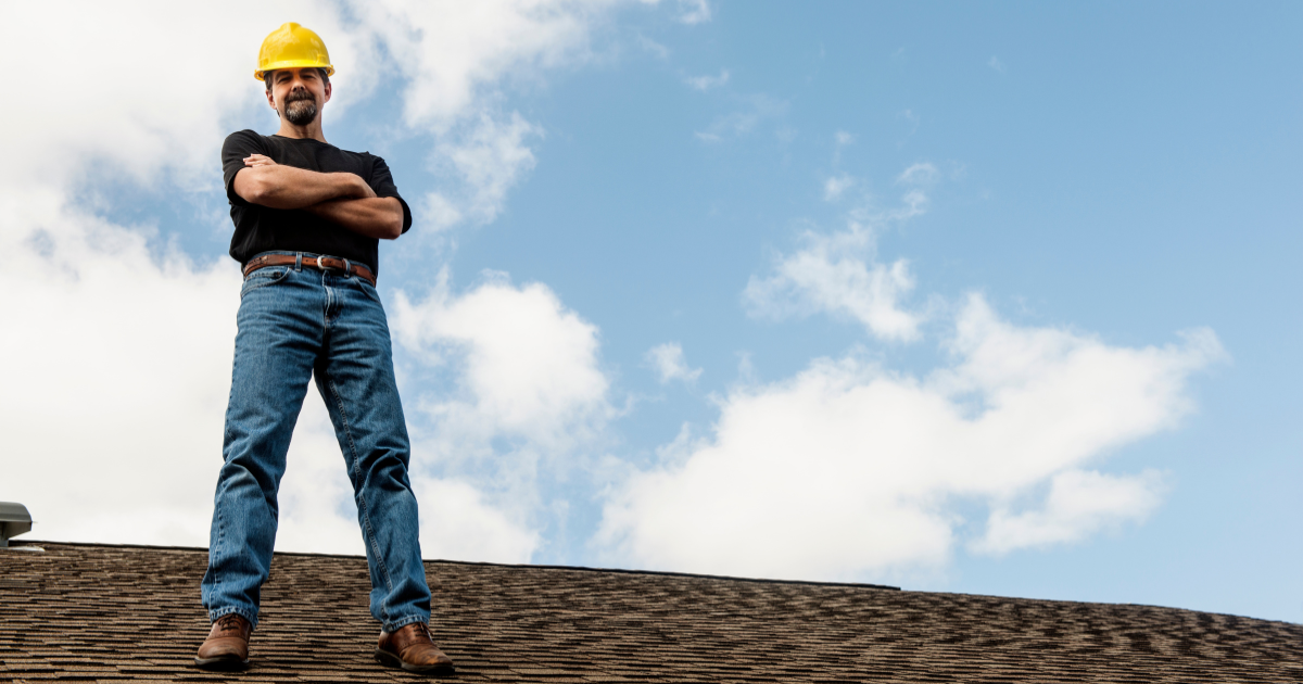 Public adjuster standing on a shingle roof in a hard hat, ready to inspect storm damage for a Dallas