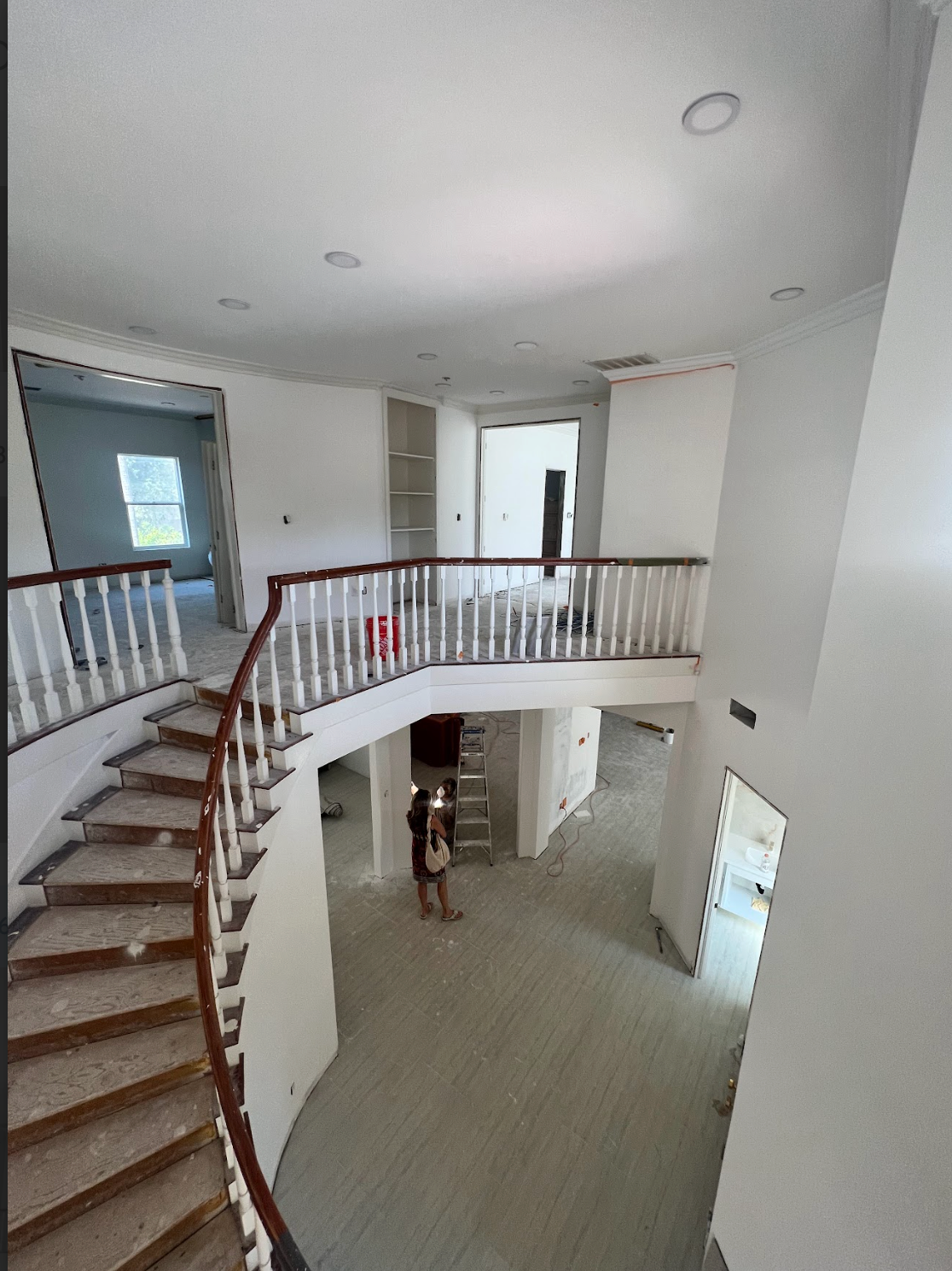 Two-story home interior with curved staircase.