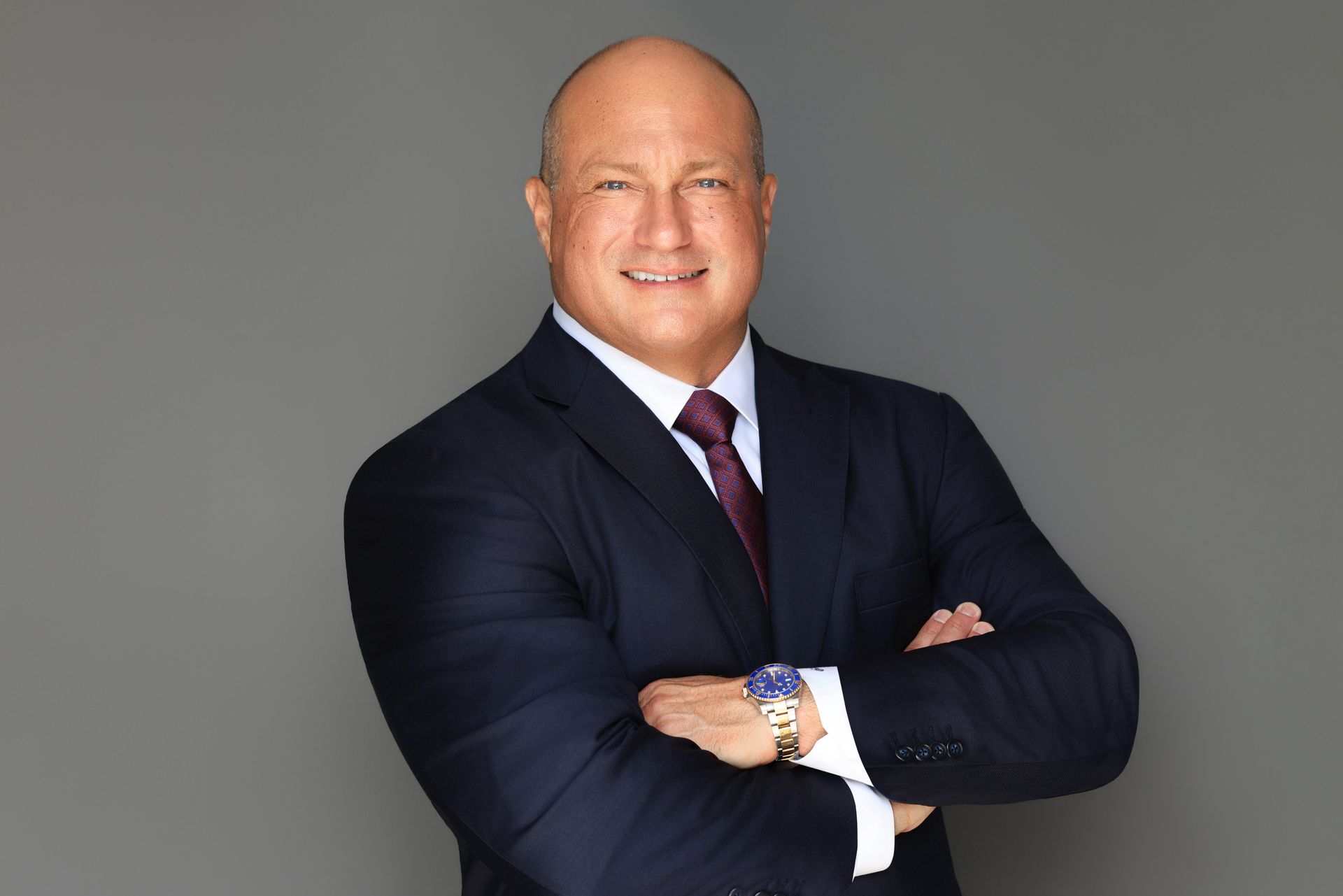 A man in a suit and tie is smiling for the camera.