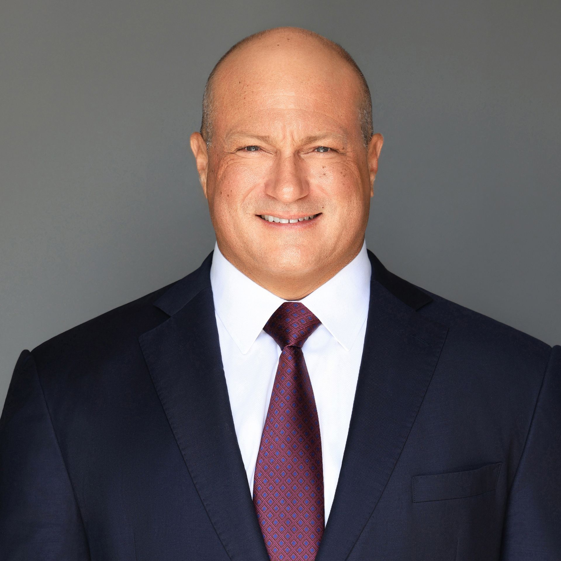 A man in a suit and tie is smiling for the camera.