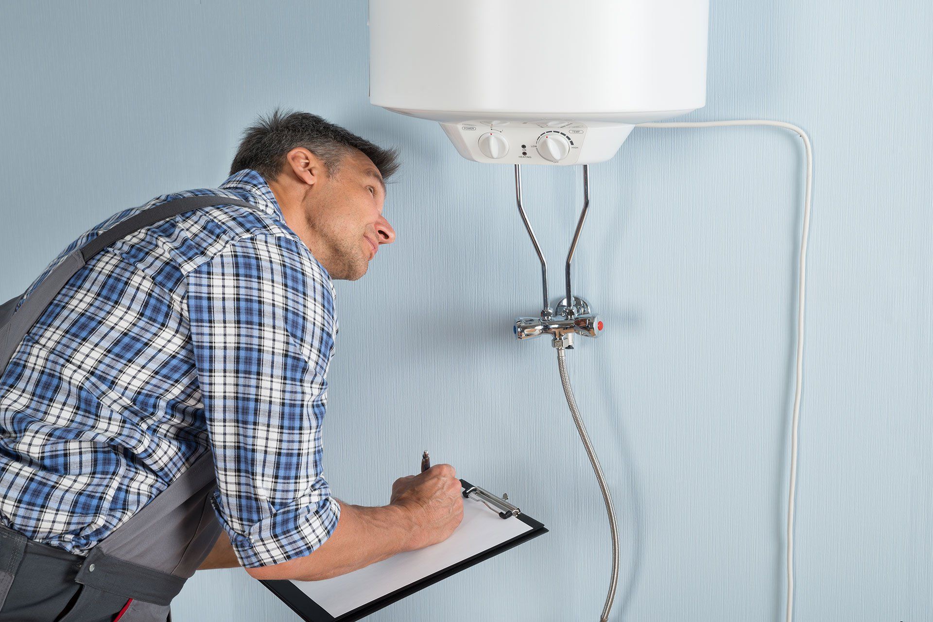 A picture of a man inspecting a boiler