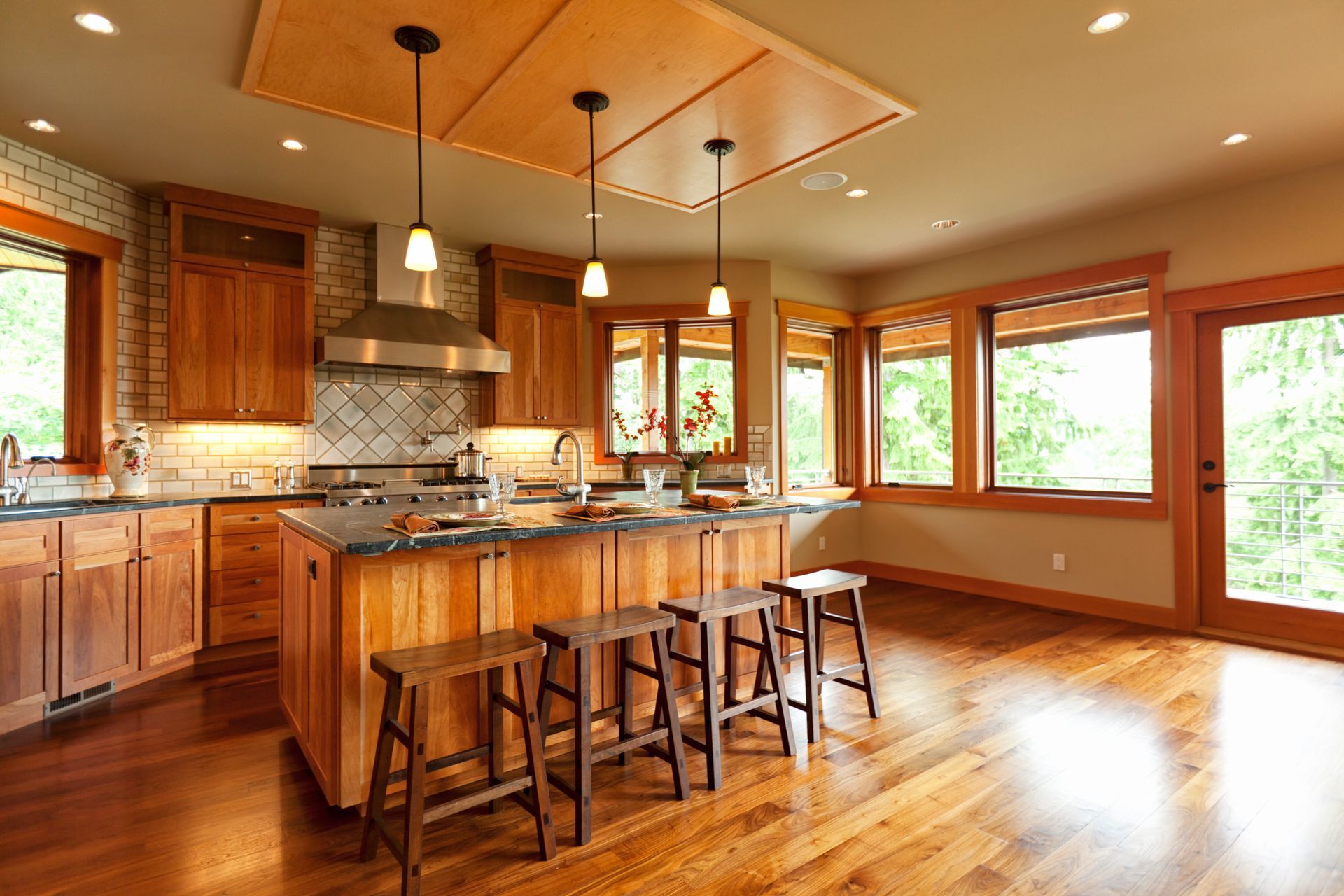 A kitchen with wooden cabinets and stools and a large island. A kitchen with wooden cabinets and stools and a large island.