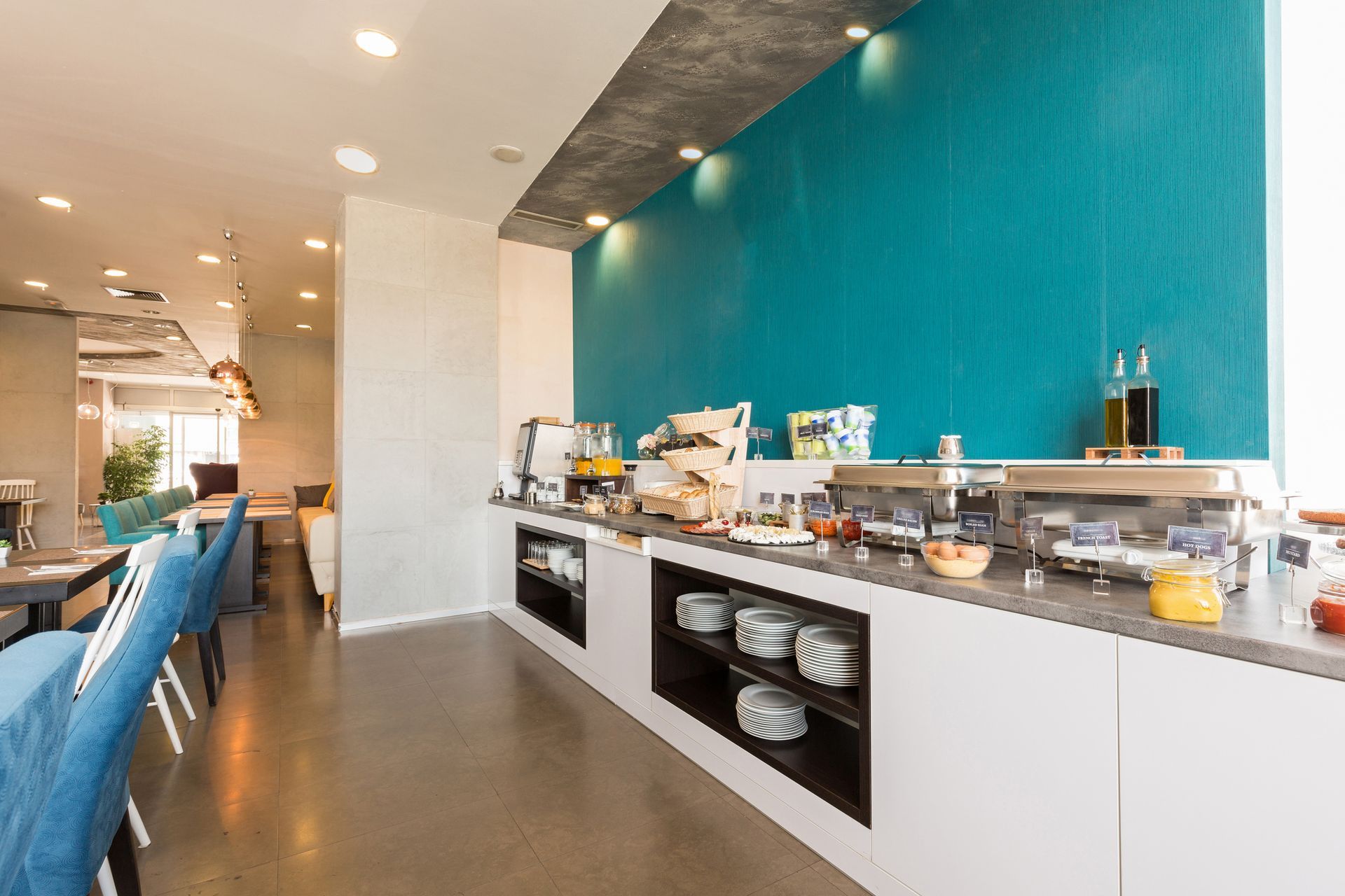 A buffet line in a restaurant with a blue wall. A buffet line in a restaurant with a blue wall.