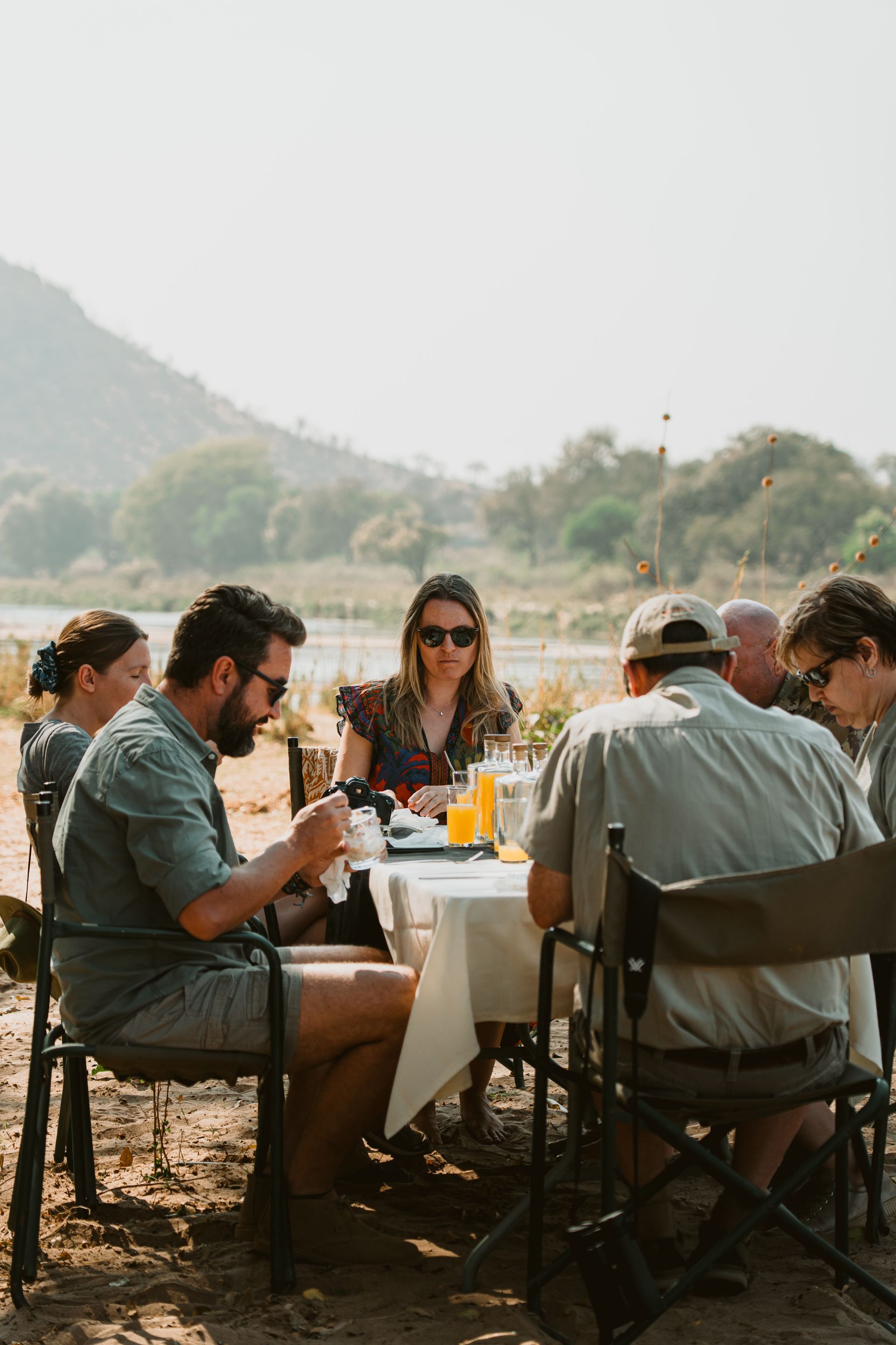 Bundox guests eating at an outdoor picnic table in a sunny mountain setting