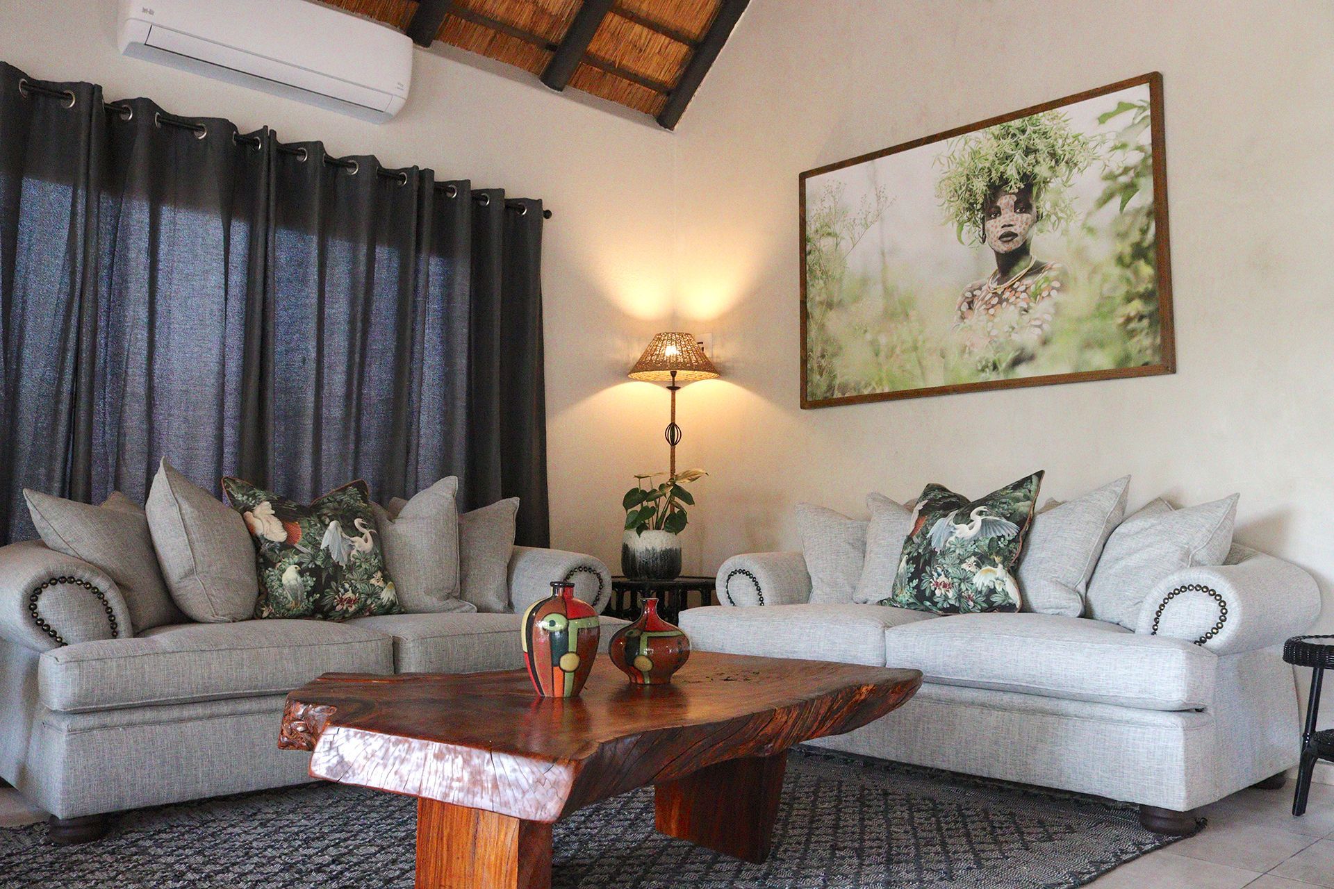 Living room with two gray couches, a wooden coffee table, and a nature painting, in a lodge-style setting.