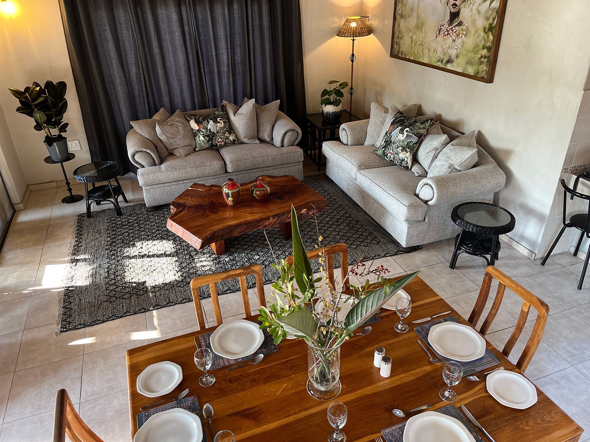 Living room with dining table set for six. Couches, rug, and decor create a comfortable space.
