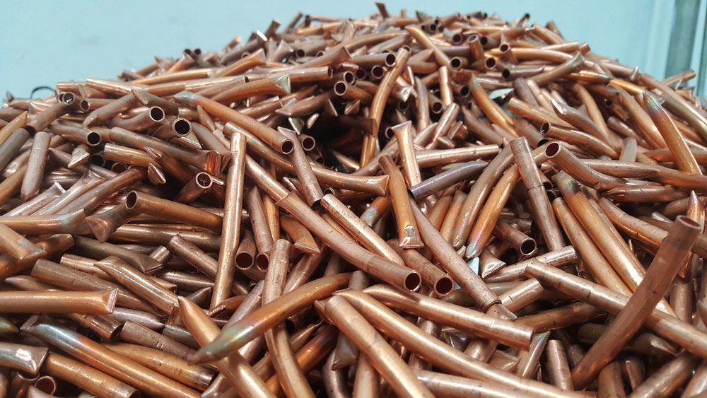 A Pile of Copper Pipes Sitting on Top of Each Other on A Table — H & H Metal Recycling In Warana, QLD