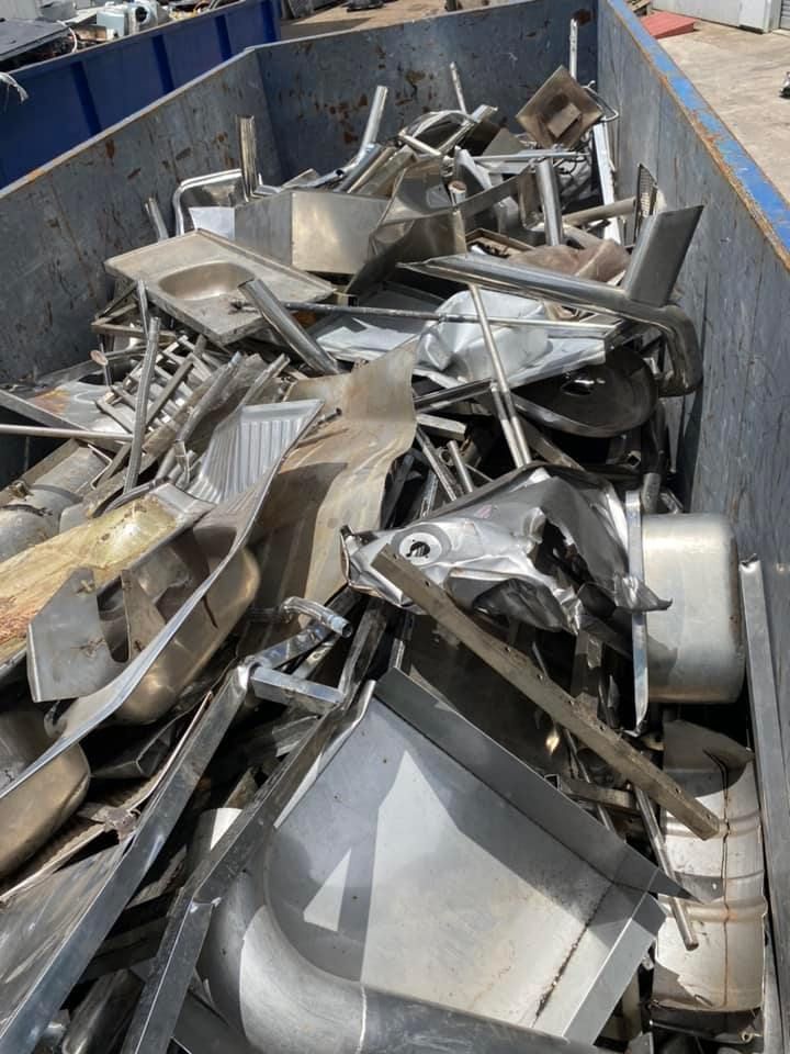 Dumpster Filled With Bent Twisted Metal And Sinks