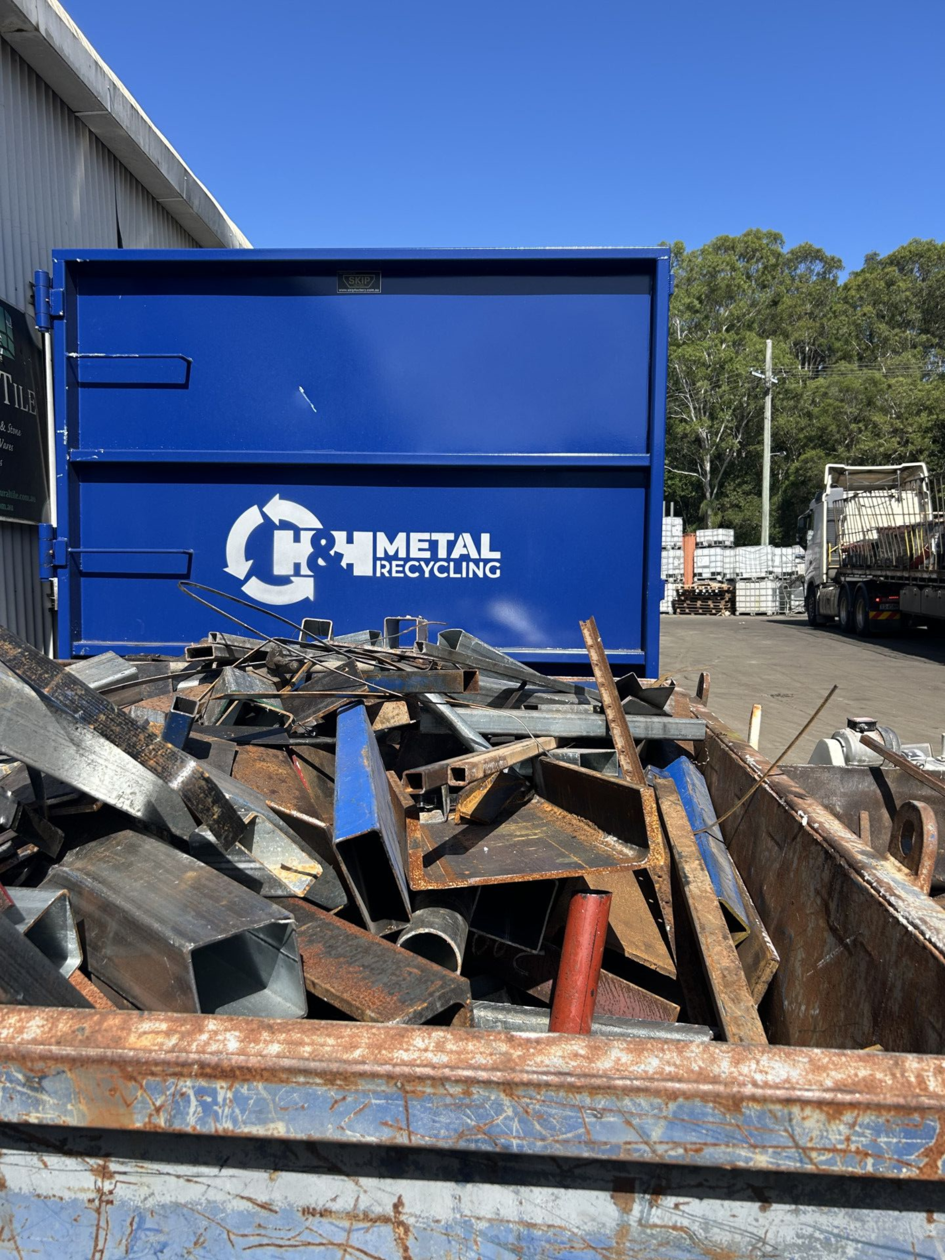 A Pile of Scrap Metal Is Sitting in Front of A Building — H & H Metal Recycling In Coolum, QLD