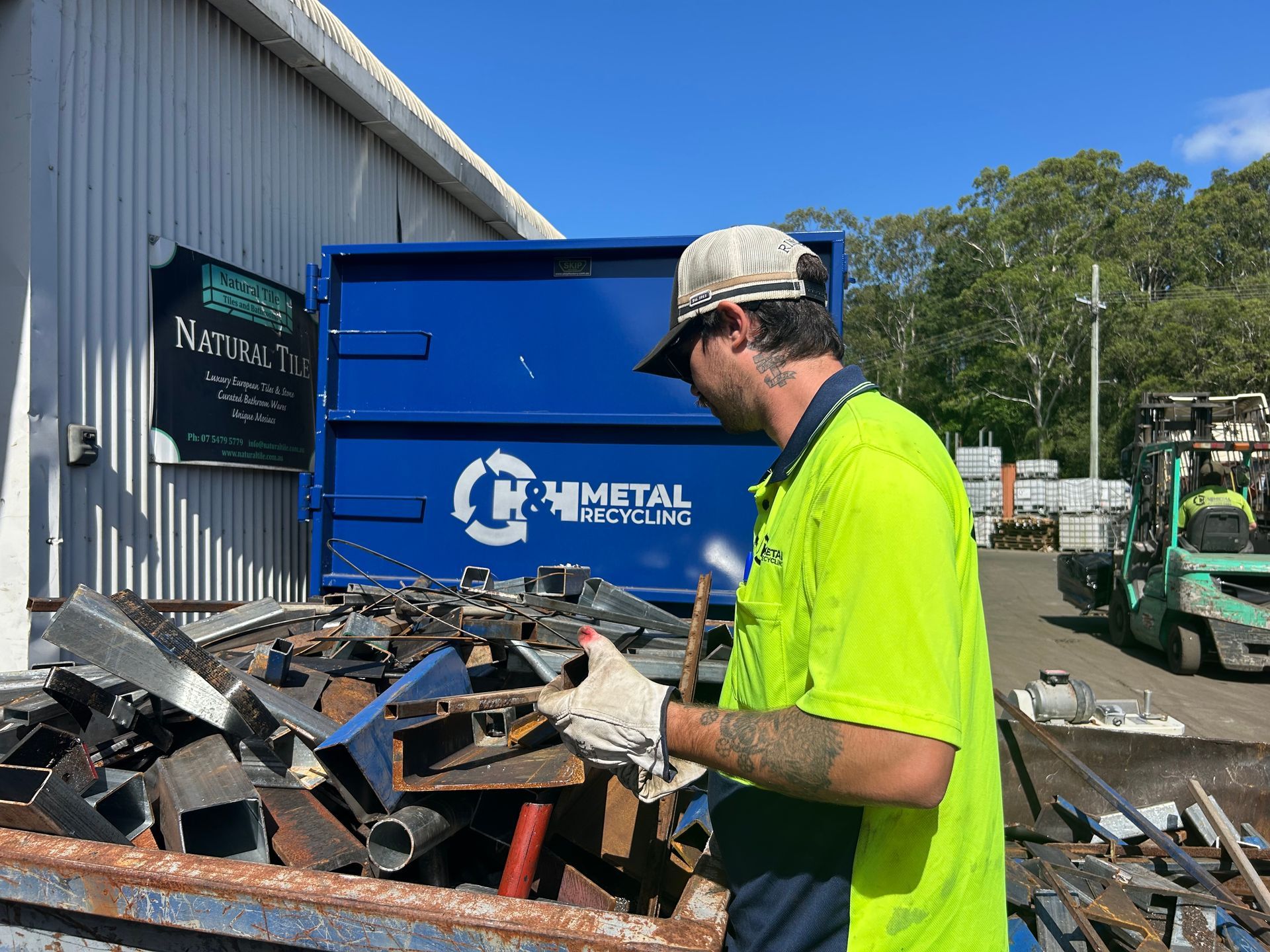A Worker in a Bright Yellow Shirt and Gloves Sorts Scrap Metal — H&H Metal Recycling in Beerwah, QLD
