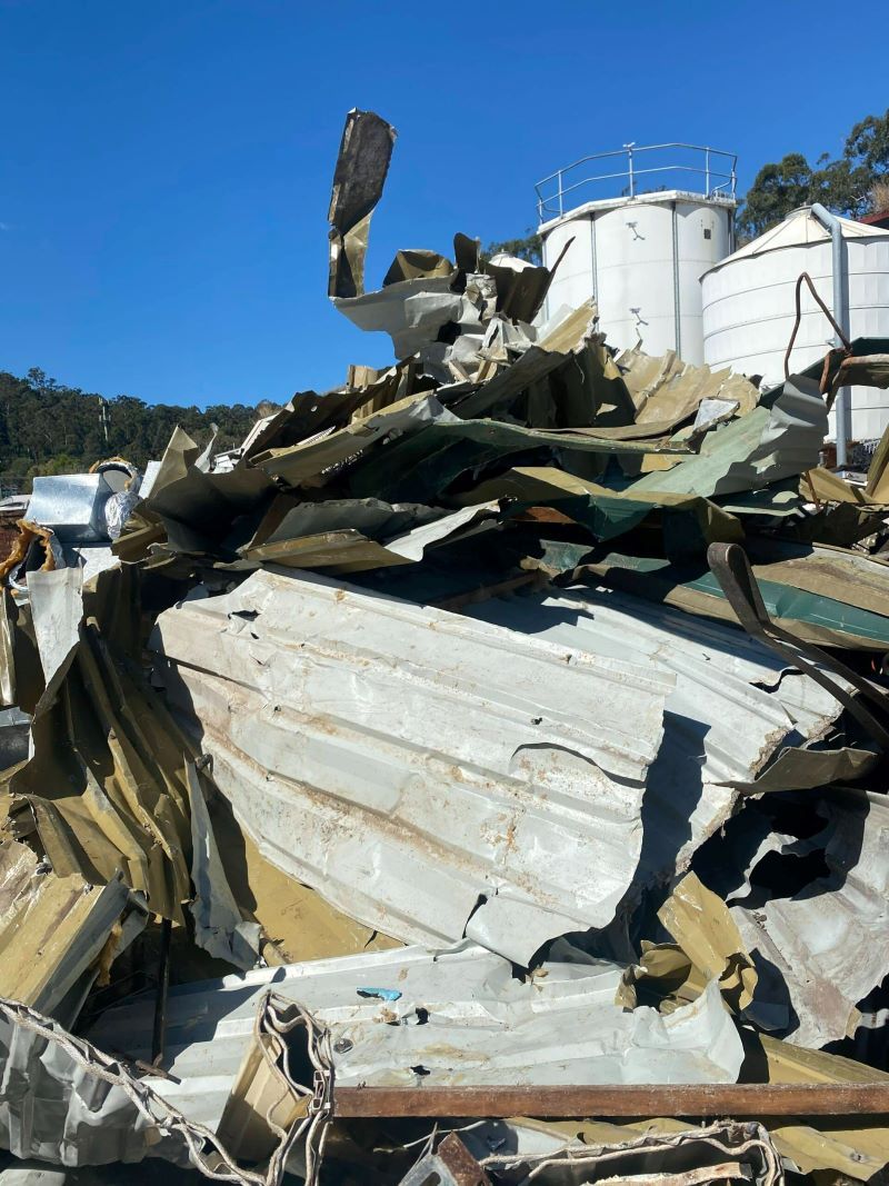 A Pile of Scrap Metal Is Sitting in Front of A Building — H & H Metal Recycling In Nambour, QLD