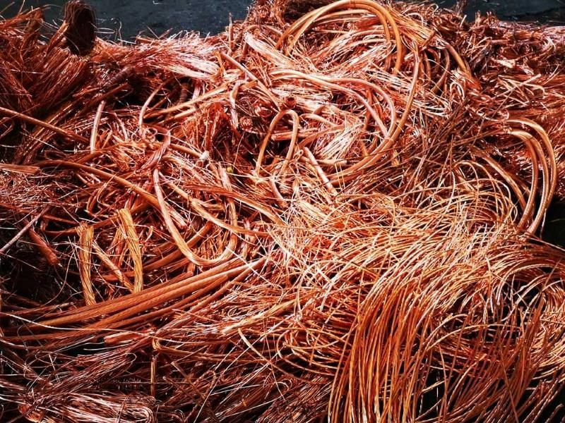 A Pile of Copper Wire Is Laying on A Black Surface — H & H Metal Recycling In Warana, QLD