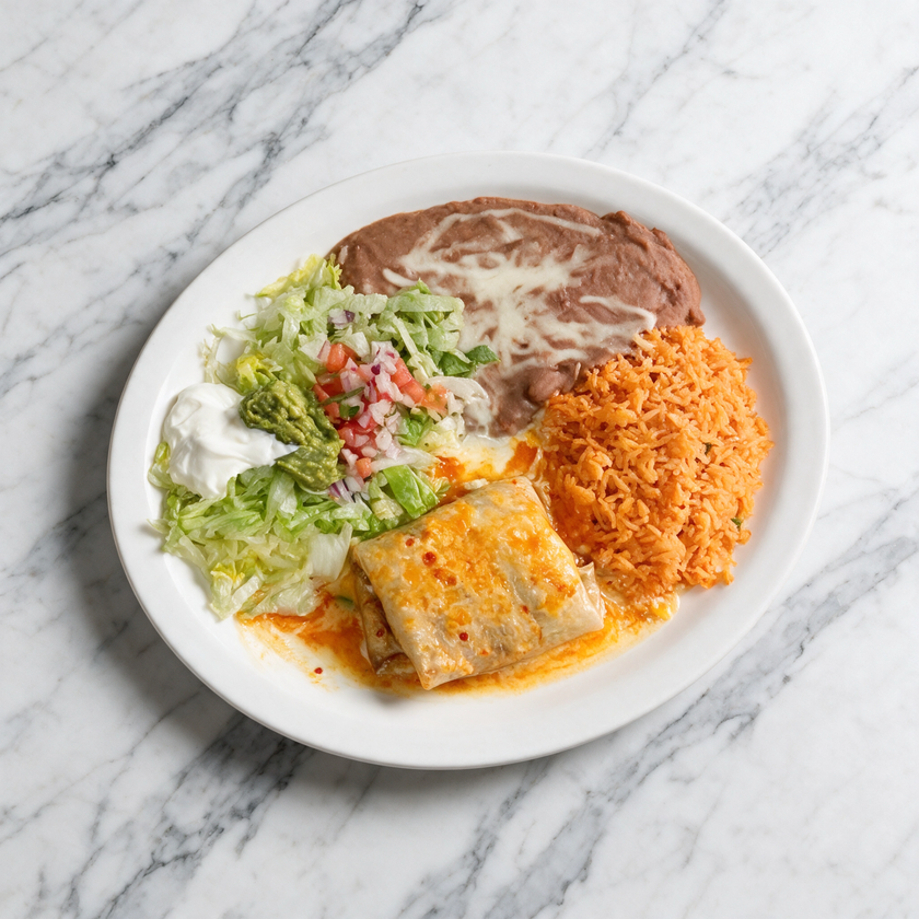 Plate with refried beans, rice, salad, and enchilada on a white marble table