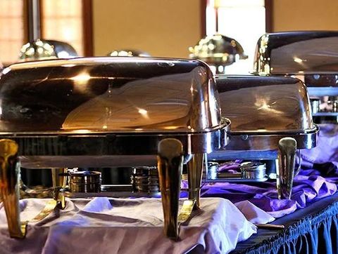 Chrome buffet chafing dishes on a table at a catered event