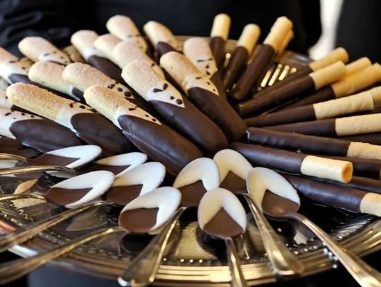 Assorted chocolate-dipped wafer sticks arranged in a circular display on a tray
