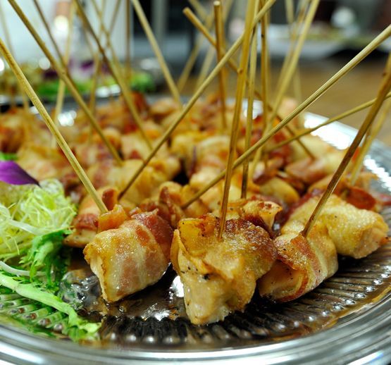 Skewered grilled chicken bites on a silver platter with garnish and toothpicks