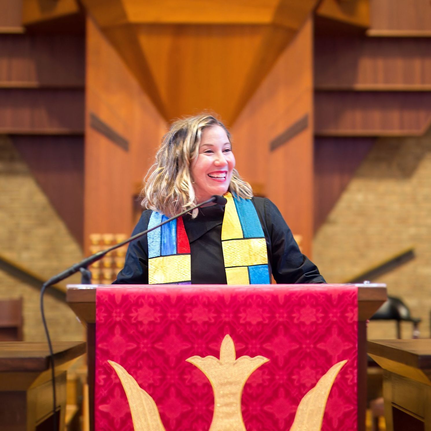 A woman is giving a speech at a podium in a church.