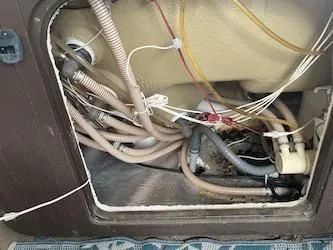 The inside of a bathtub with a lot of wires coming out of it.
