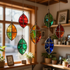 Colorful stained-glass hanging ornaments by a sunlit window in a cozy room