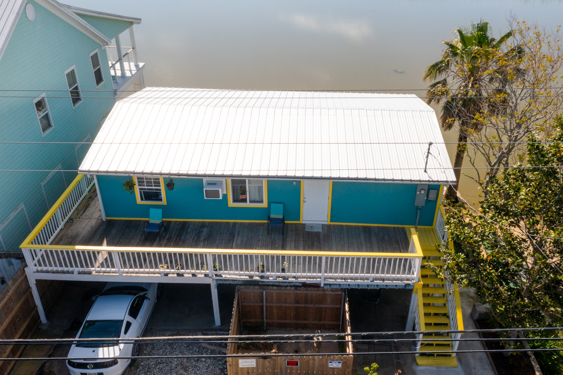 An aerial view of a house with a car parked underneath it