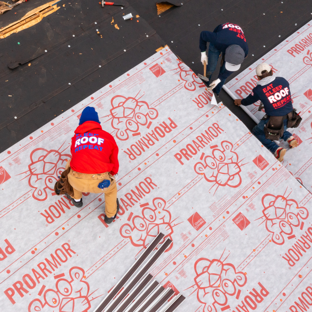 A group of people are working on a proarmor roof