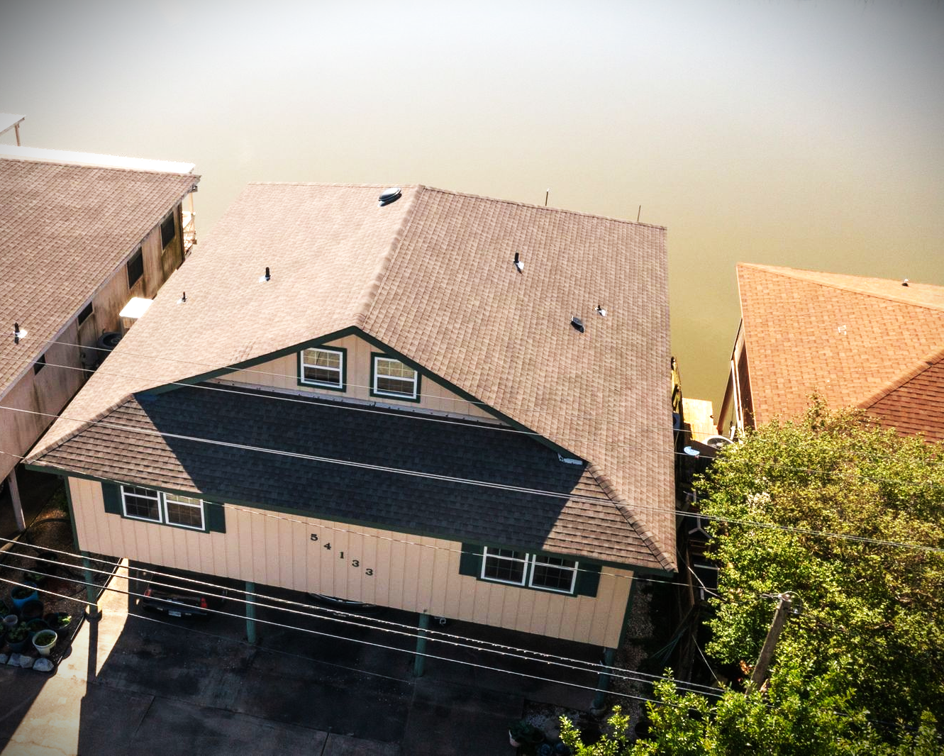 An aerial view of a house next to a body of water