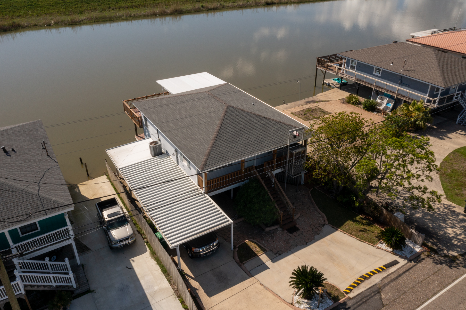 An aerial view of a house next to a body of water.