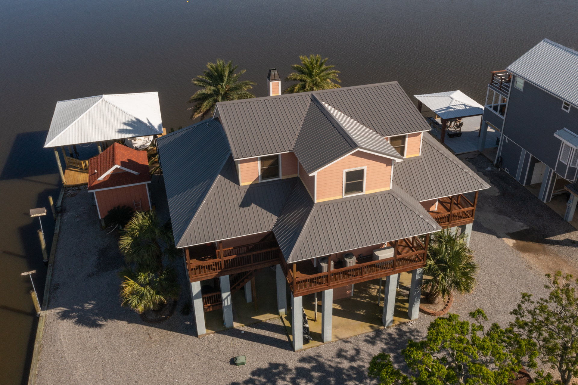 An aerial view of a large house next to a body of water.