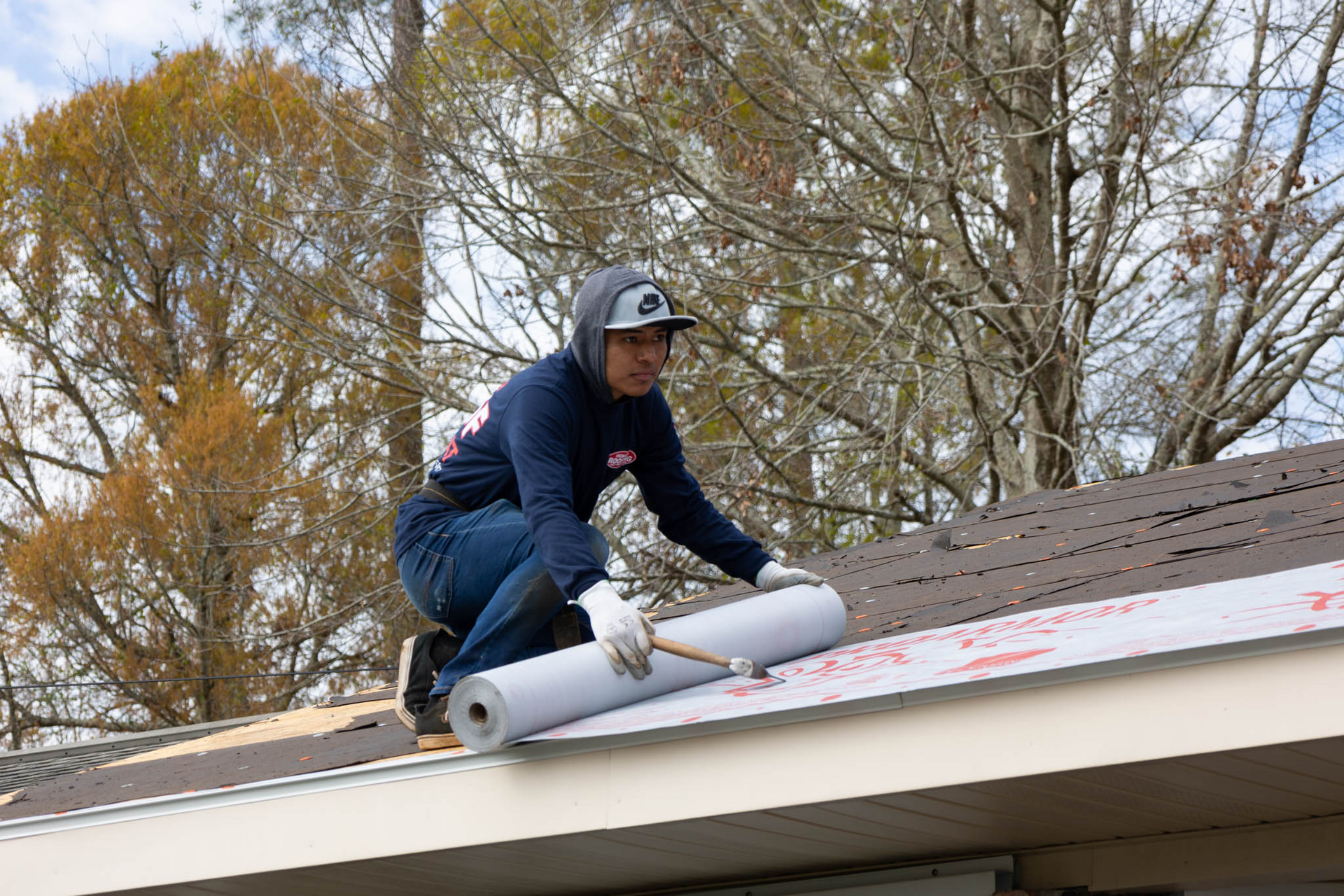 A man is working on the roof of a house.