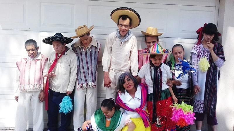 Un grupo de personas posan para una fotografía frente a la puerta de un garaje.
