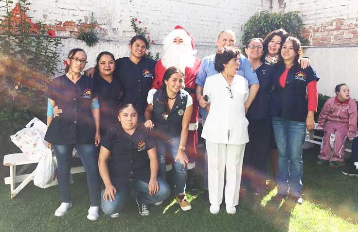 Un grupo de personas posando para una foto con Papá Noel.