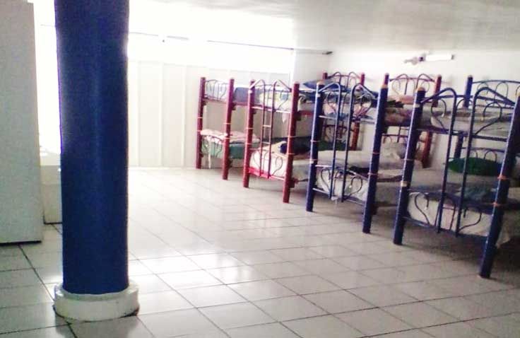 Una habitación con literas y una columna azul.